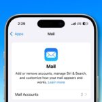 iPhone screen showing the Mail app settings. Heading: Mail. Options to manage accounts, Siri & Search, and customization. Background is blue sky gradient.