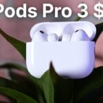 White AirPods Pro 3 in an open charging case resting on green plant leaves, with large text above reading AirPods Pro 3 $199 against a blurred brick background