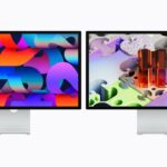 Two sleek, silver Apple desktop monitors side by side, each showing vibrant abstract artwork with bold colors and geometric shapes on a clean white background