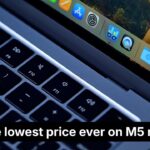 Close-up of a MacBook Air keyboard and screen dock, with a bold banner reading Grab the lowest price ever on M5 models and a red corner label saying NEW