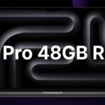 Open MacBook Pro laptop displaying abstract dark curved pattern, with large white text across the screen reading M5 Pro 48GB RAM against a dark purple and black background